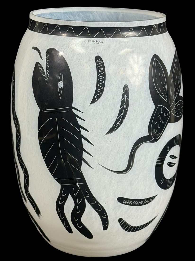Kosta Boda Vallien Art Glass Vase by Ulrica Hydman: Kosta Boda Scandinavian studio art glass vase designed by Ulrica Hydman Vallien featuring stylized faces, animals, and abstract motifs in black on frosted white glass. Signed in script underneath its