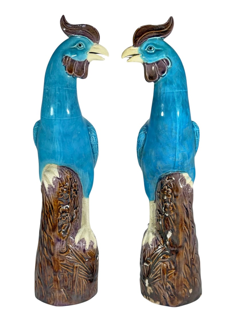 Pair of Chinese Ho-Ho Phoenix Glazed Ceramic Birds: Pair of Chinese ceramic Ho-Ho phoenix figures with turquoise glazed bodies, cream legs, and brown crests, standing on stylized rocky bases with floral relief decoration. Hollow interiors with vent hol