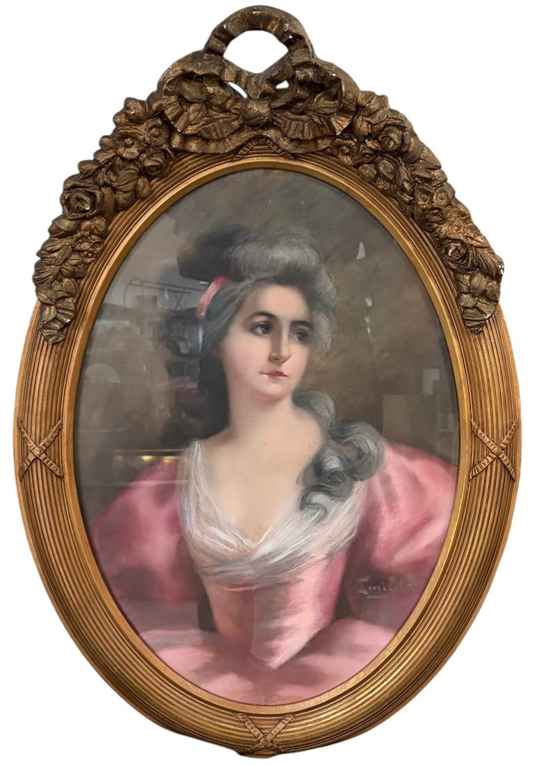 Antique Signed Emilita Pastel Portrait of a Woman: Emilita, antique pastel portrait of a young woman in three-quarter view wearing a pink dress with white bodice and powdered hair with ribbon. Signed to the lower right. Housed in an ornate oval frame.