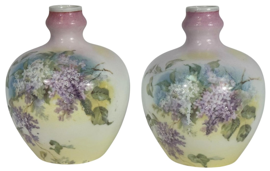 Pair of European Hand-Painted Porcelain Bud Vases: Pair of petite porcelain bud vases, delicately hand-painted with clusters of lilacs in soft shades of lavender, white, and green. The vases feature a rounded baluster form with a gently flared neck, t