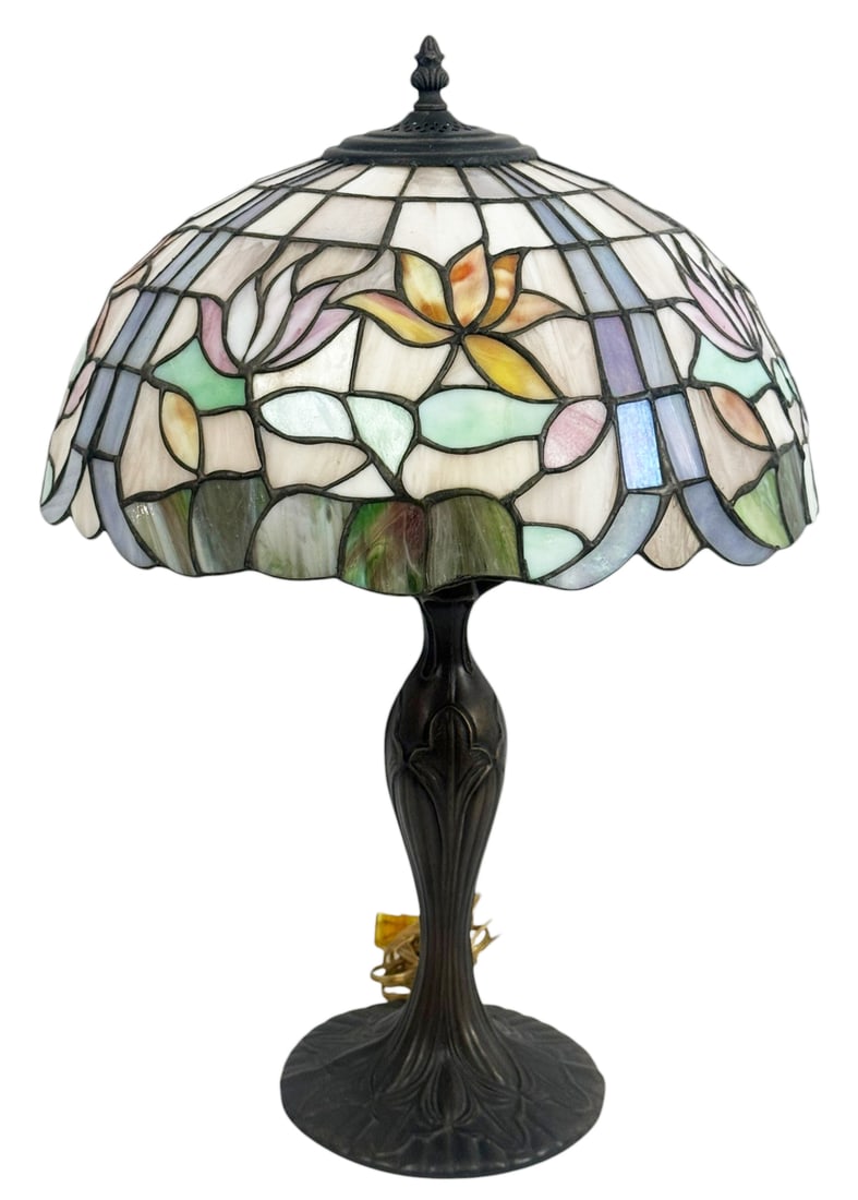 Tiffany Style Floral Stained Glass Table Lamp: Tiffany style table lamp featuring a domed stained glass shade with multicolor floral motifs in pink, yellow, and green tones set among cream and light blue panels. The leaded glass shade rests on a d