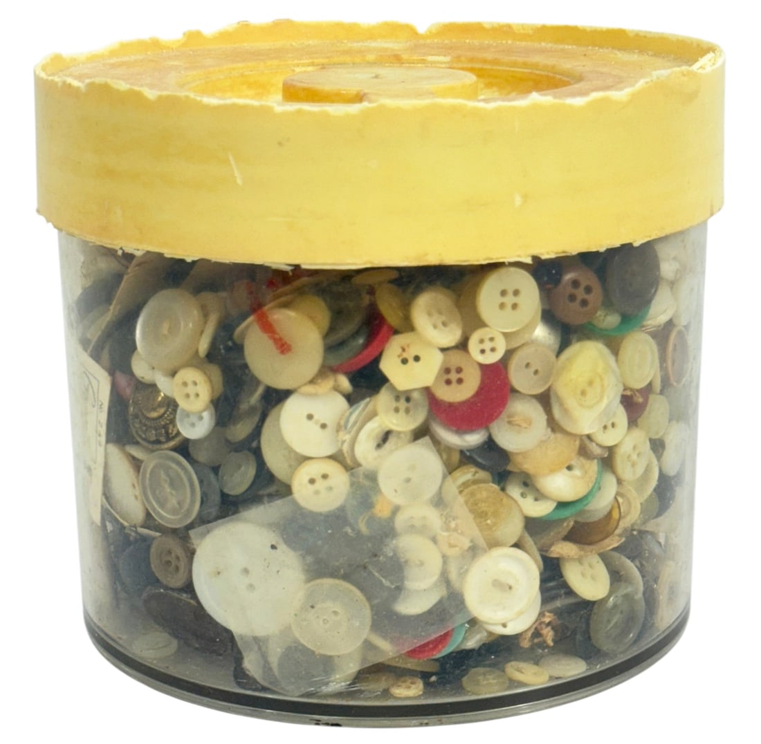 Lot of Hundreds of Vintage Mixed Sewing Buttons: Mixed vintage sewing buttons in assorted sizes materials and colors stored in a clear plastic container. The lot includes hundreds of buttons including plastic shell and metal examples used for garmen
