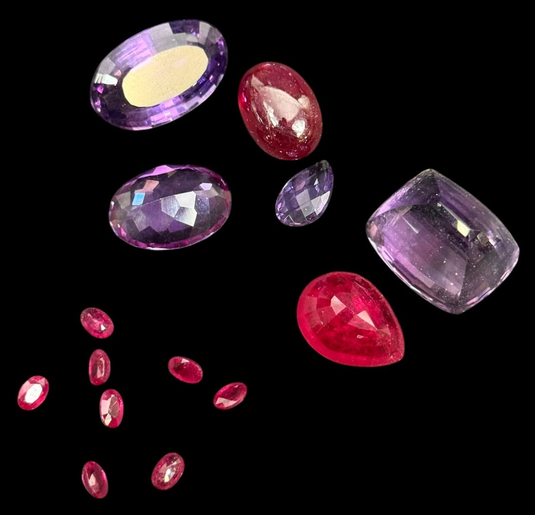 Breakout Jewelry Mixed Loose Gemstones 14pc LOT: Lot of fourteen loose mixed gemstones suitable for jewelry making or collection. The group includes several faceted purple stones in oval, cushion, and pear cuts, two larger red faceted stones, and