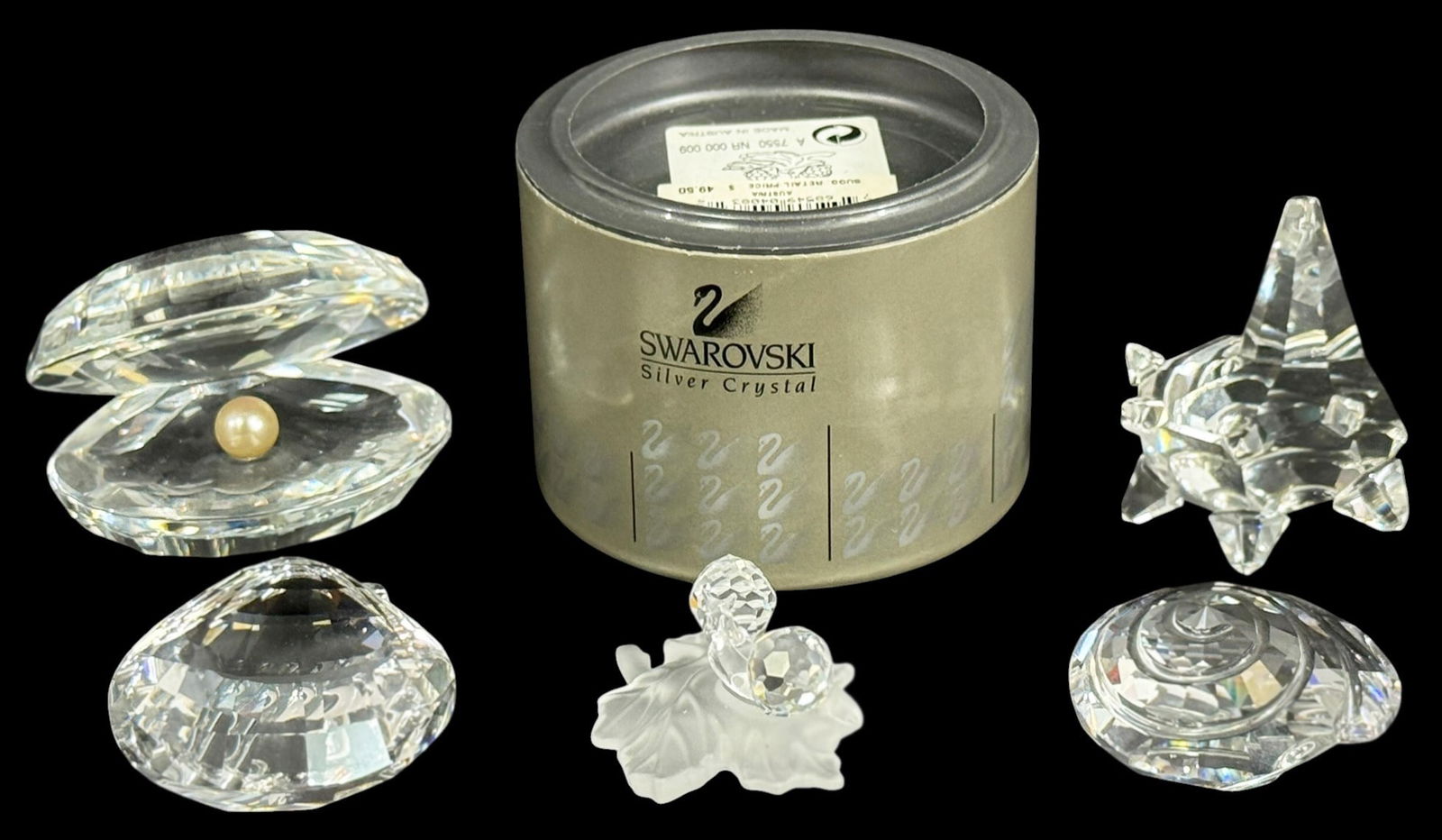 Swarovski Crystal Figurines & Paperweights 5pcs: Swarovski, a group of five crystal figurines and decorative objects. The lot includes a clam shell with pearl, star form candleholder, spiral shell form, faceted dome paperweight, and a frosted leaf w