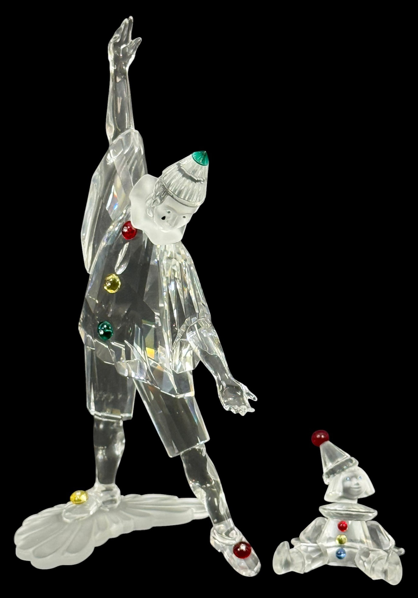 Swarovski Crystal Harlequin & Clown Figurines LOT: Swarovski, a group of crystal clown figurines including the Harlequin with outstretched arms and a seated clown figure. Each is formed in clear faceted crystal with colored accents on the costume and