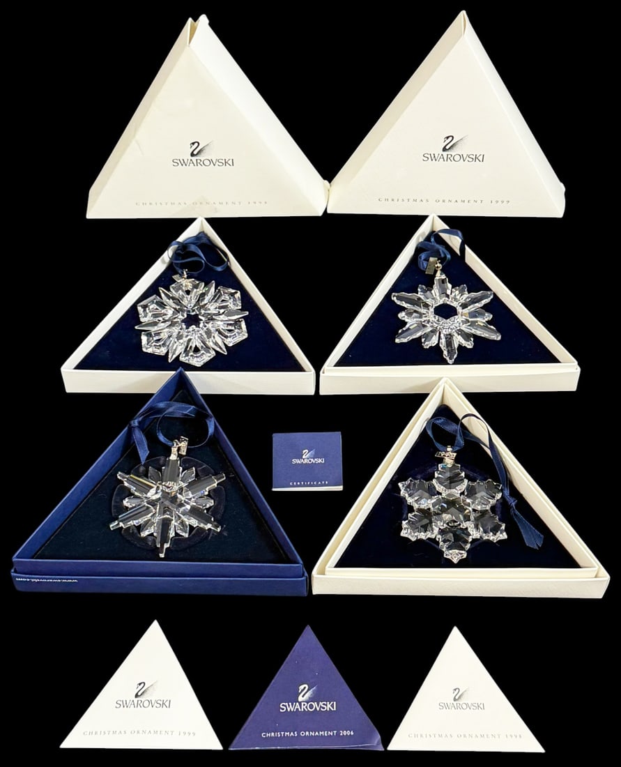 Swarovski Crystal Annual Christmas Ornaments 4pcs: Lot of four Swarovski crystal annual Christmas star ornaments. The group includes 1996, 1998, 1999, and 2006 designs, each with faceted crystal star forms and blue ribbon hangers. All are marked Swaro