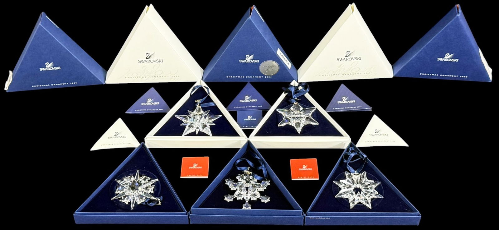 Swarovski Crystal Annual Christmas Ornaments 5pcs: Lot of five Swarovski crystal annual Christmas star ornaments. The group includes 2000, 2005, 2006, 2007, and 2008 designs with faceted crystal snowflake forms and blue ribbon hangers. Each ornament i