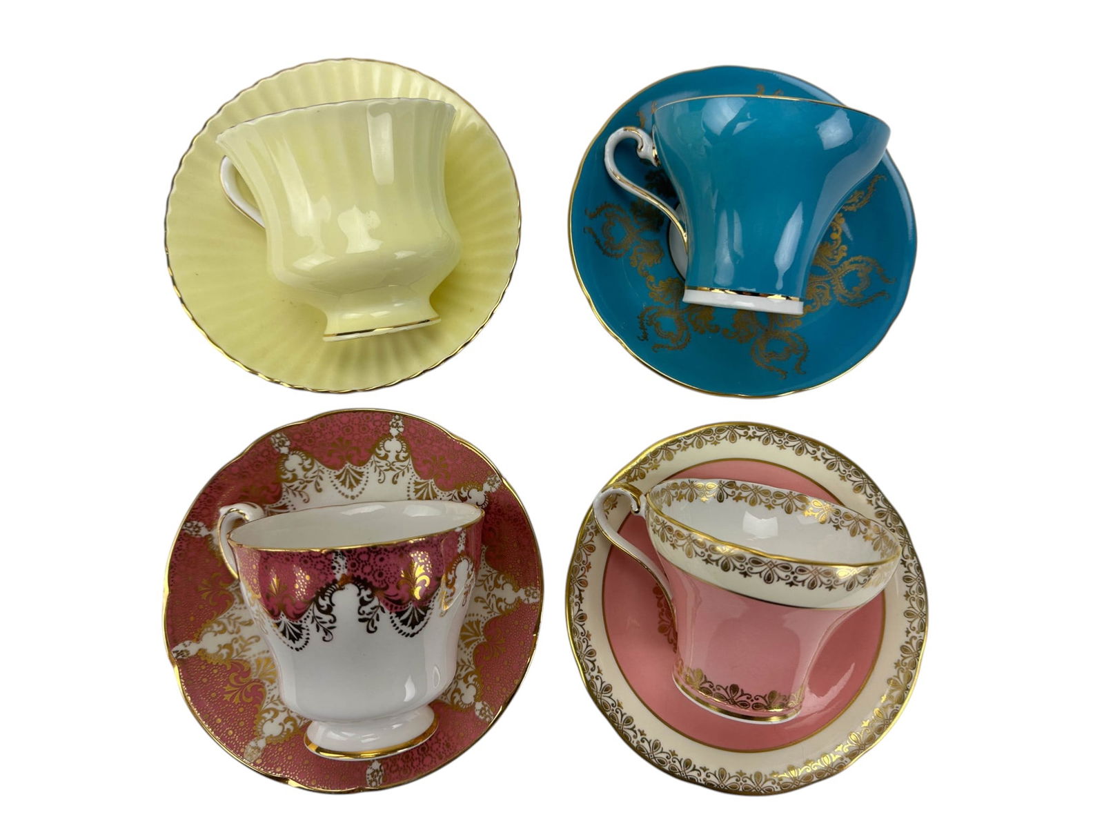 Paragon & Aynsley England Tea Cups Saucers 4pc SET: Group of four English bone china teacups with matching saucers. Includes two examples by Aynsley and two examples by Paragon (two sets), total of four sets. Decorations include floral motifs, gilt bor