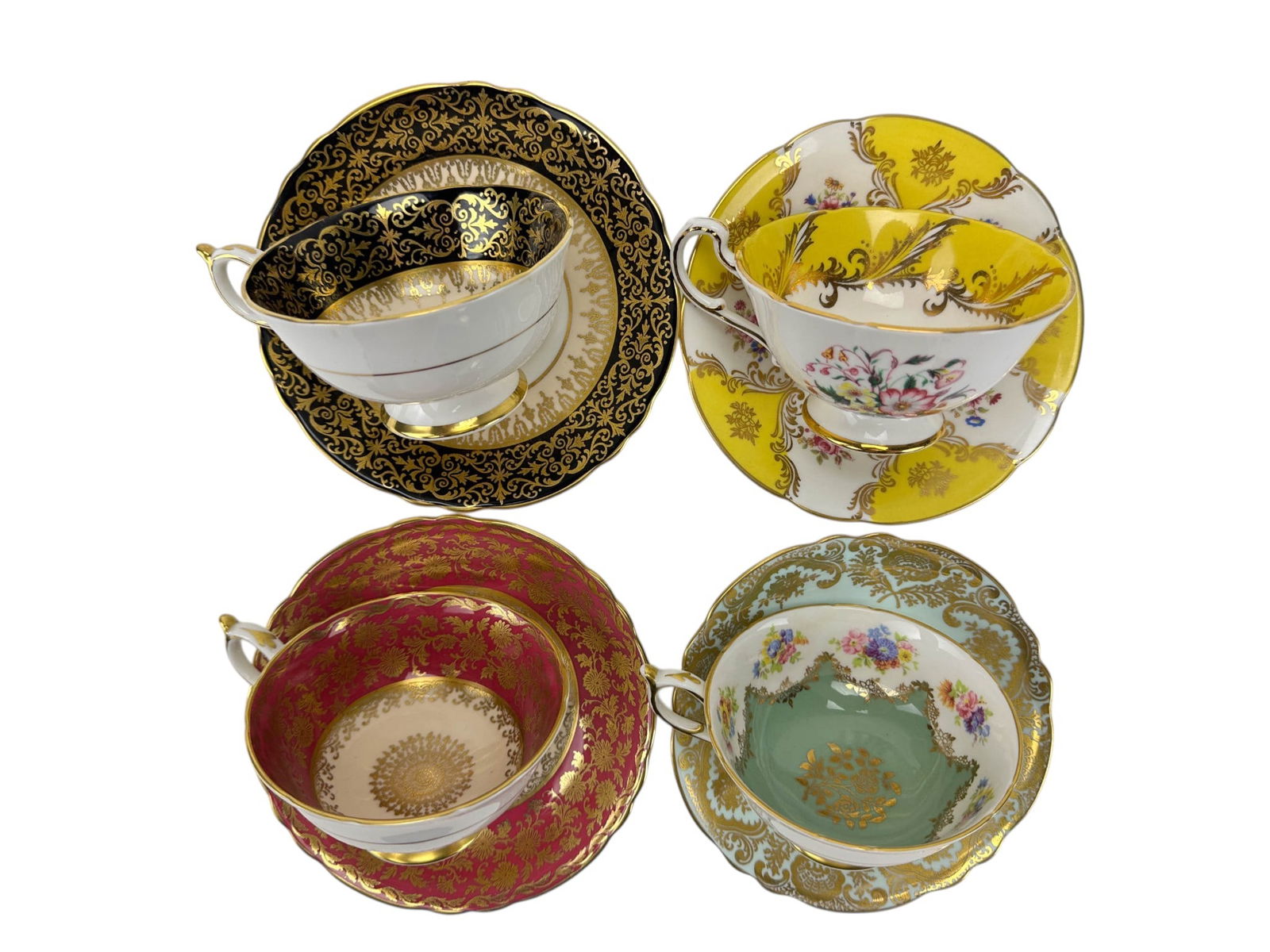 Paragon Floral & Gold Gilt Tea Cup Saucer 4pc SET: Group of four English bone china teacup and saucer sets by Paragon. Each displays floral center motifs with gilt pattern bands over cobalt, teal, pink, yellow ground designs. Cups measure approximatel