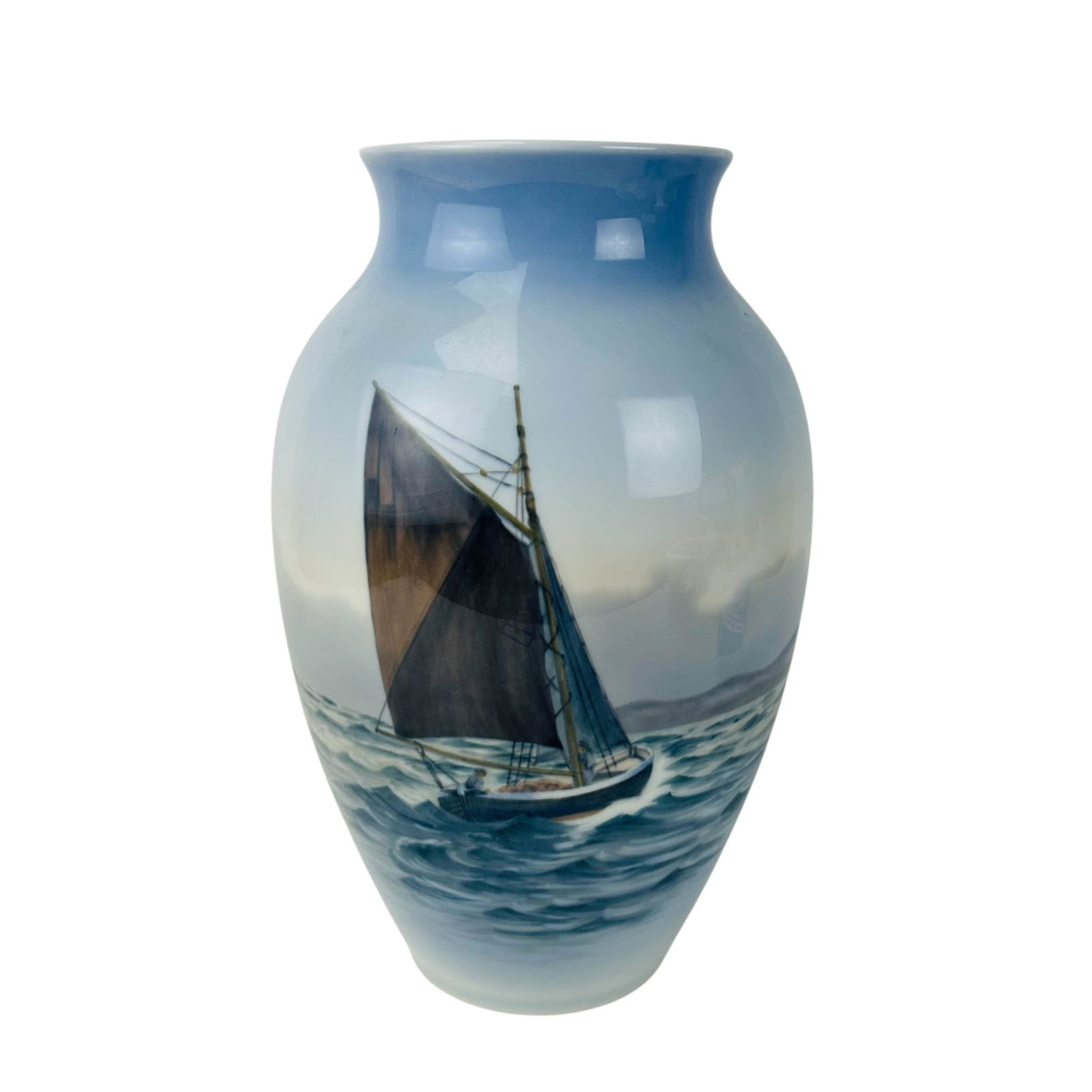 Royal Copenhagen Porcelain Nautical Ship Vase 13": Royal Copenhagen Denmark porcelain vase featuring a hand painted maritime scene with a sailing ship underway on rolling ocean waves. Decoration wraps partially around the body with a shaded sky and di