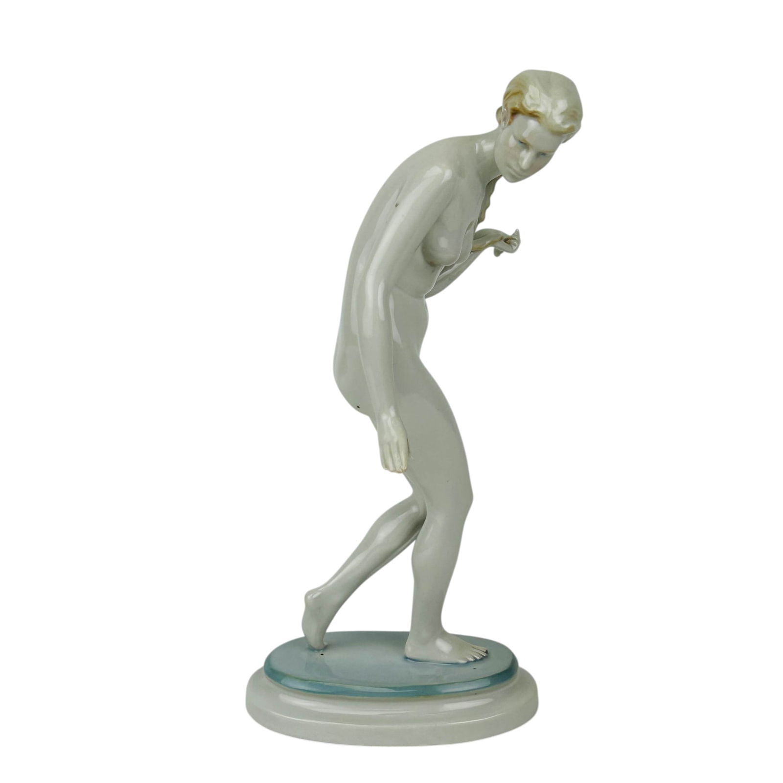 Zsolnay Pecs Art Deco Porcelain Nude Lady Figurine: Zsolnay Pecs Hungary porcelain curio cabinet display figurine. The sculpture depicts a nude woman in a graceful forward leaning pose, stepping across an oval base. The minimalist white glaze highlight