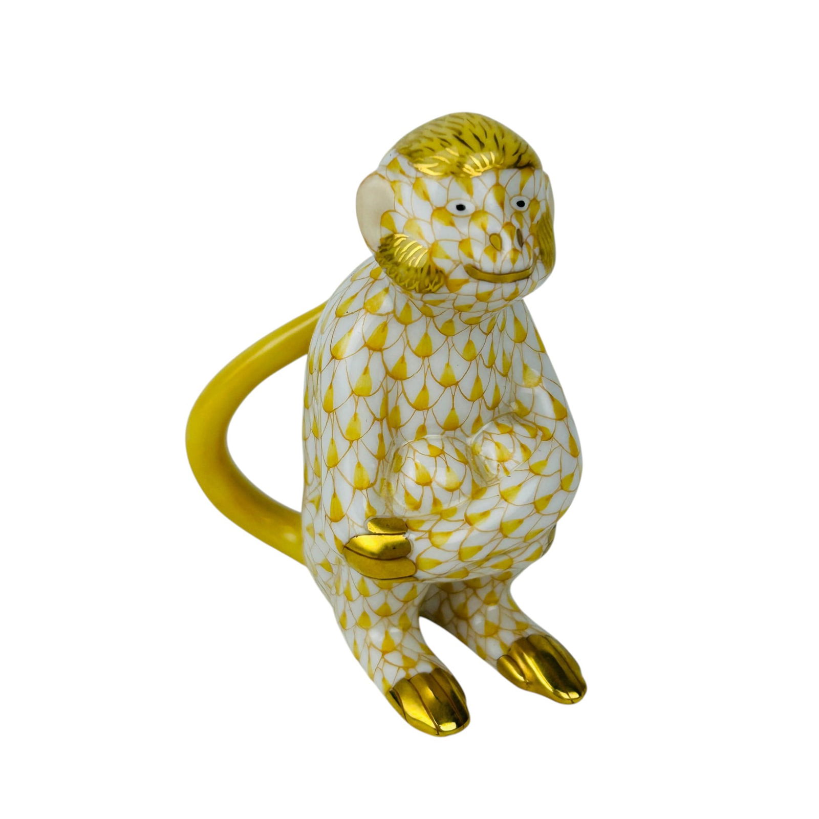 Herend Butterscotch Fishnet Monkey Figurine: Herend Hungarian porcelain monkey figurine featuring a Butterscotch coloration in the signature fishnet scale pattern in gilt tones over a white ground. The seated primate displays detailed facial fea