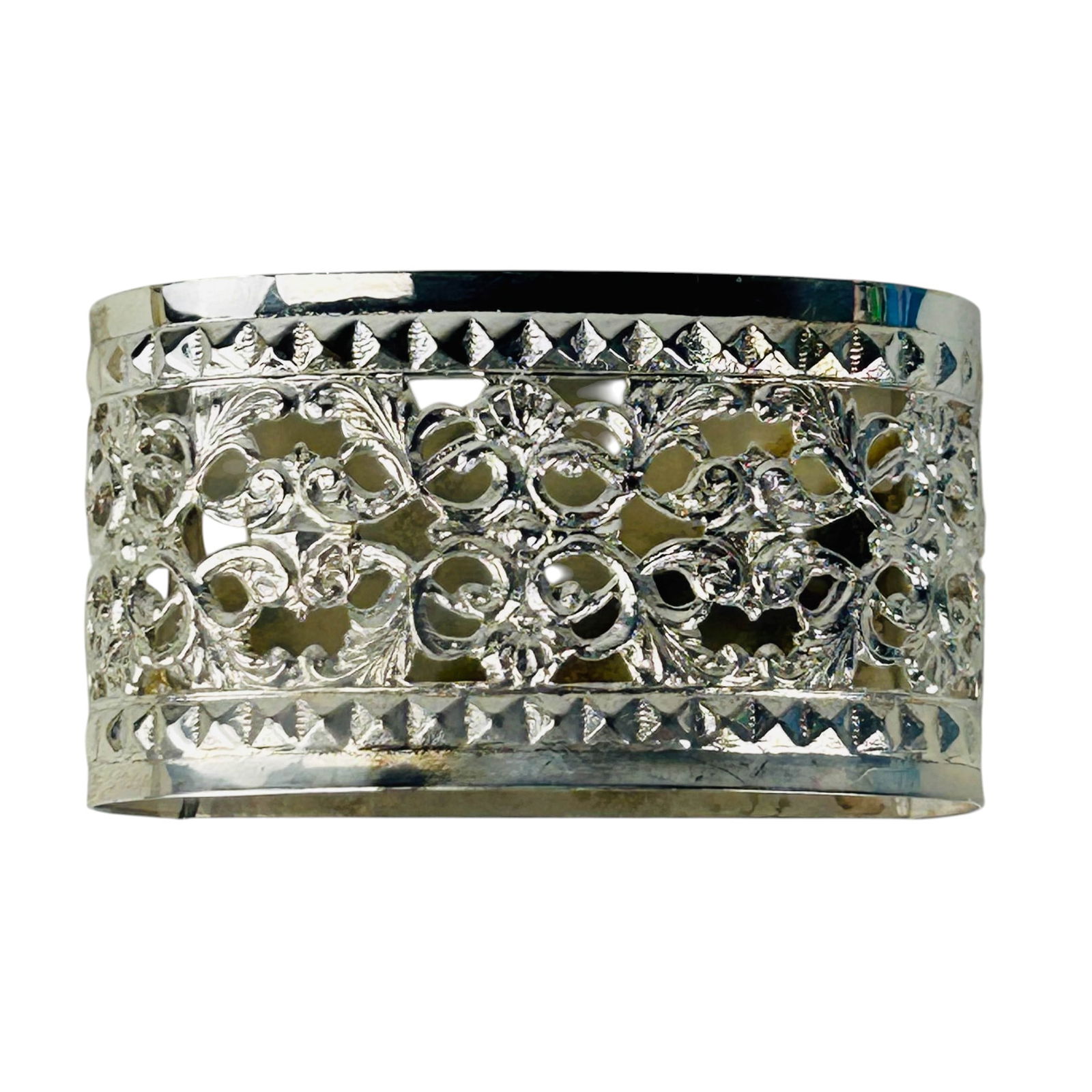 Sterling Silver Pierced Filigree Napkin Rings 12pc: Set of twelve oval form sterling silver 925 table napkin rings. Design showcases an ornate pierced reticulated filigree pattern with scrolling foliage bordered by a geometric inspired design on opposi