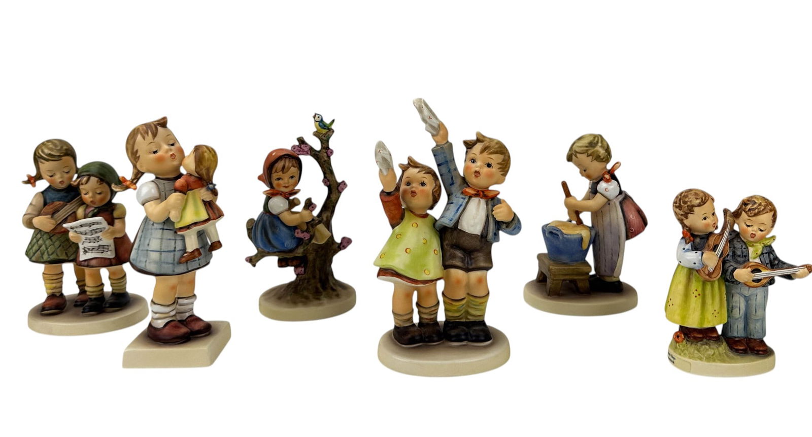 Hummel Goebel Child Figurines Original Box 6pc LOT: Group of six Goebel M.I. Hummel German porcelain figurines depicting child figures in activity scenes. Includes Apple Tree Girl (Hum 141/1), Baking Day (Hum 330), Kiss Me (Hum 311), A Musical Duet (Hu