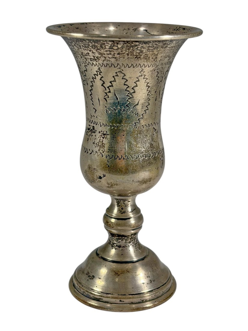 Antique Judaica Sterling Kiddush Wine Goblet: Judaica sterling silver Kiddush wine goblet featuring a classic baluster form with a flared rim and stepped circular base. The body is decorated with engraved foliate and scroll motifs, adding traditi