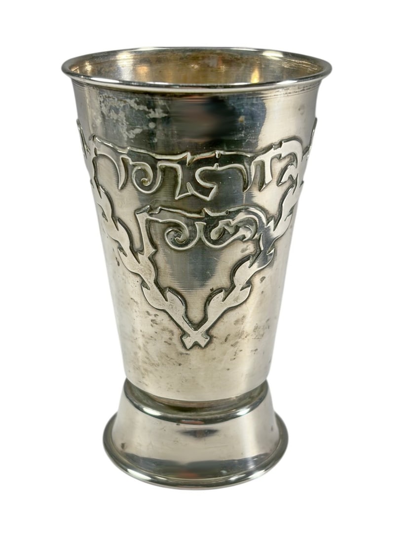 Antique Judaica Sterling Silver Kiddush Goblet: Judaica sterling silver Kiddush goblet with tapered form, flared rim, and stepped base, featuring Hebrew inscription within foliate cartouche. Marked sterling 925 to its underside. Total weight approx