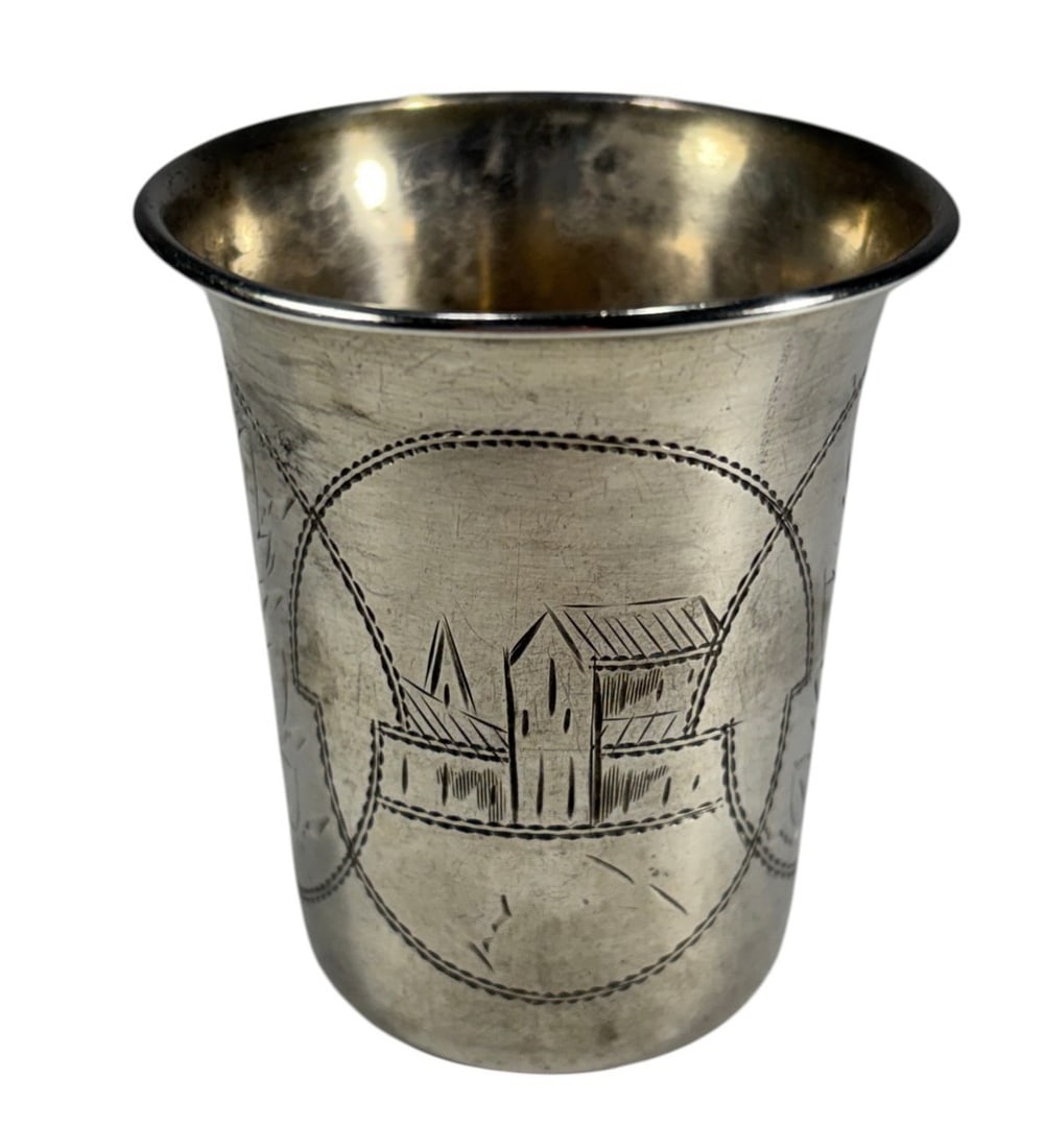 Antique Russian Silver Kiddush or Vodka Cup: Russian silver cup with slightly flared cylindrical form, engraved with village scenes and foliate cartouches. Marked with 84 standard and attributed to maker Stakhy Kondratyevich Orlov. Total weight