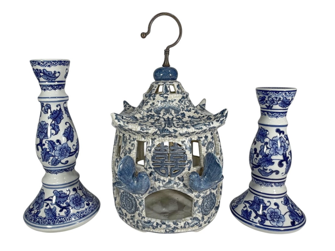 Chinese Porcelain Lantern & Candlesticks 3pc LOT: Chinese blue and white porcelain three piece set, pierced pagoda form lantern with bat handles and metal hook, and two baluster candlesticks with floral decoration on crackle ground. The largest measu