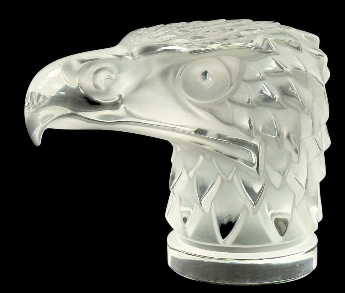 Lalique Tete d'Aigle French Crystal Mascot Figure: Lalique "Tete d'Aigle" French sculpture depicting a stylized eagle head in profile. Executed in frosted and clear crystal, the piece features finely detailed plumage with feather patterning and a shar