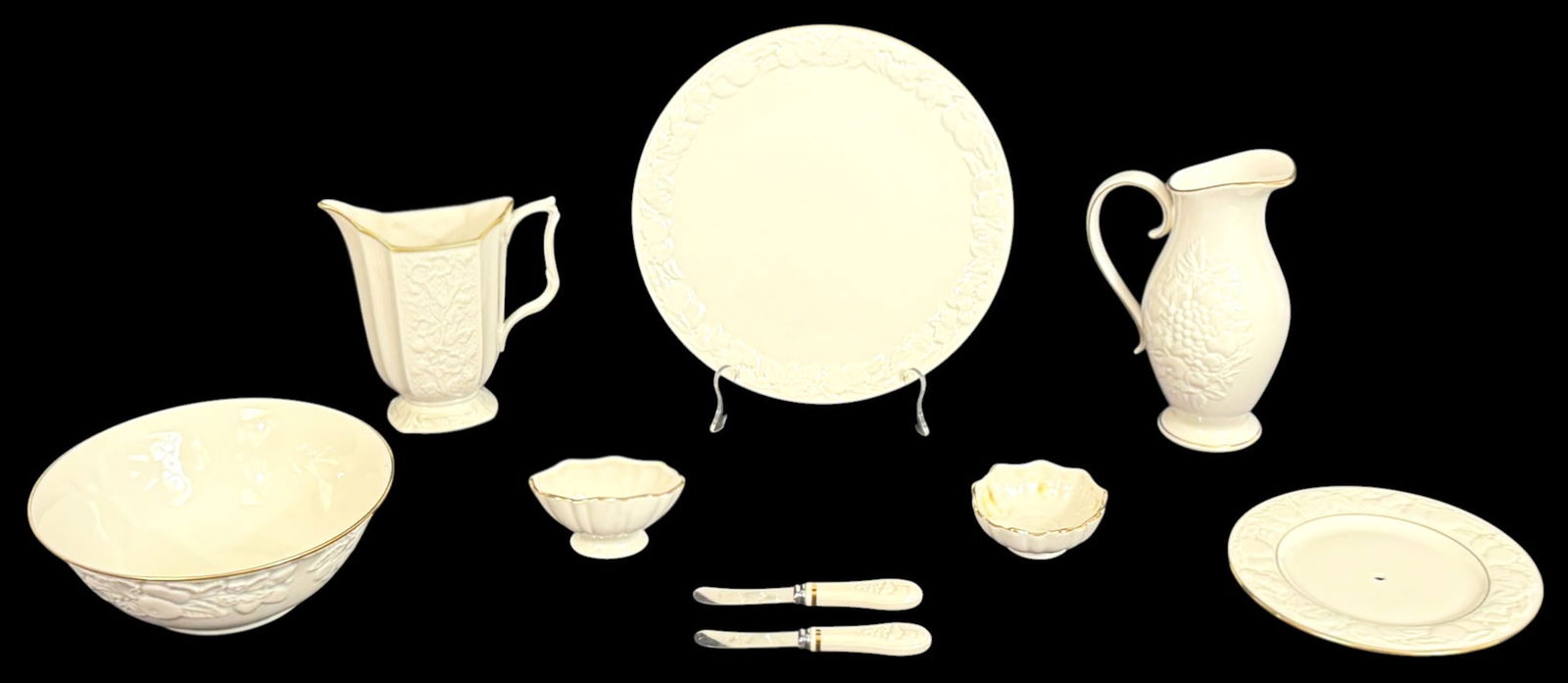 Lenox Porcelain Tableware Service Items 9pc SET: Lot of nine Lenox ivory china tableware including a handled pitcher with embossed fruit motif, a second floral relief pitcher, a large serving bowl, a round serving plate with fruit border, a centerpi