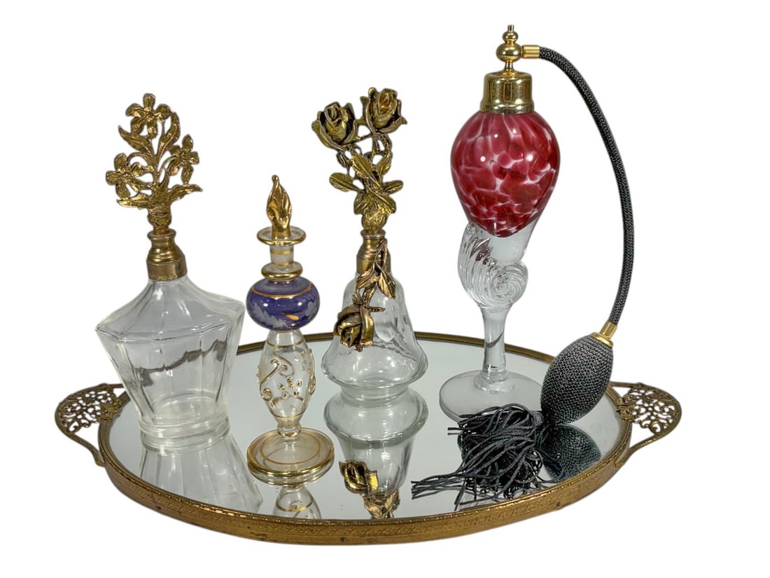 Atomizer & Others Glass Perfume Bottles & Tray 5pc: Five piece group of glass perfume bottles and vanity accessories including an atomizer with red glass reservoir and tassel bulb, two bottles with gilt metal floral mounts, a decorative stopper bottle,