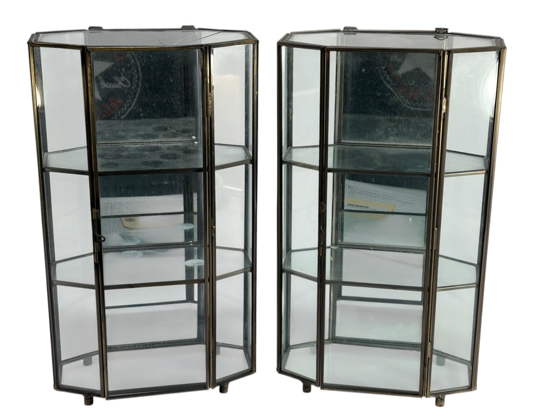 Pair Vintage Brass & Glass Miniature Wall Vitrines: Vintage brass and glass pair of wall mounted vitrines, multi panel faceted glass with hinged doors and interior shelves, polygonal form with brass tone frames, hanging loops and small feet. Each piece