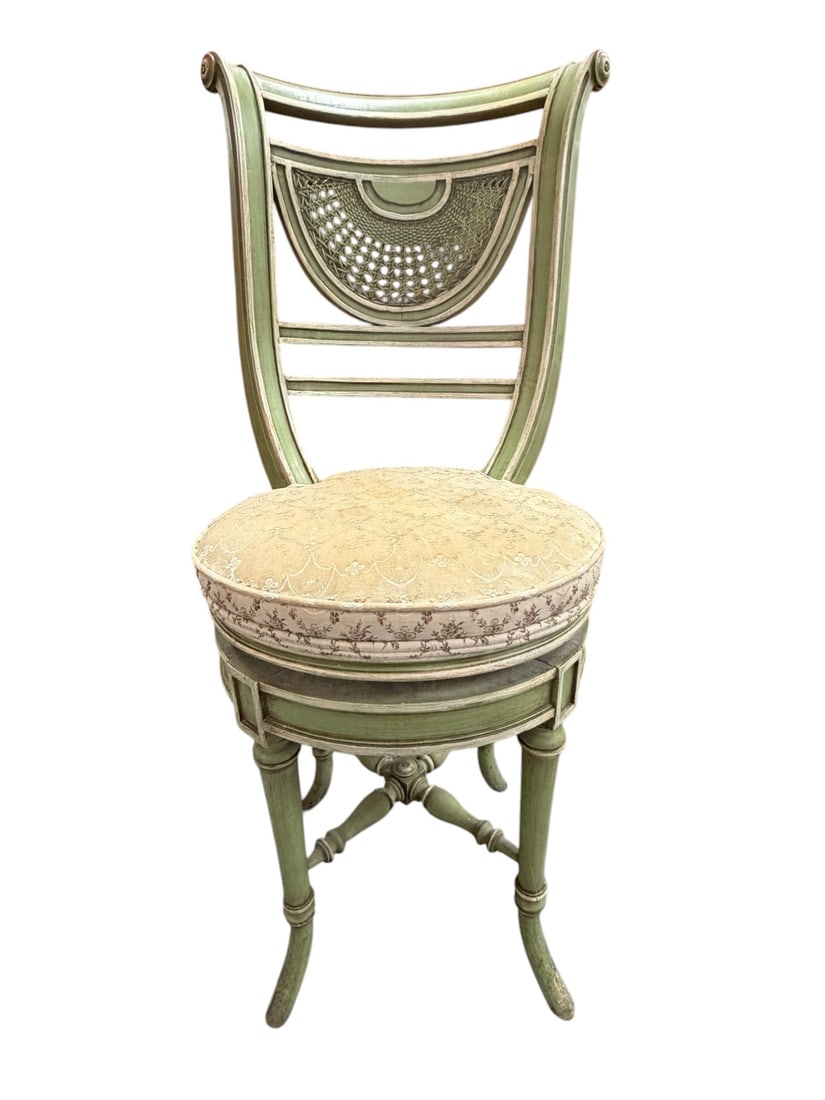 Smith & Watson Regency Style Green Rotating Chair: Smith and Watson Regency style rotating chair, painted green with distressed finish, cane inset shield back, upholstered seat with floral fabric, turned legs with X stretcher and swivel mechanism.Dime