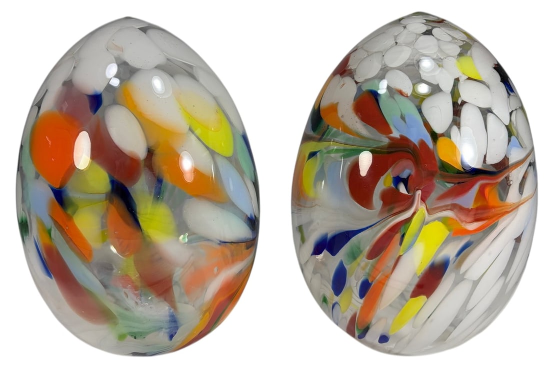 Pair of Multi Colored Art Glass Egg Sculptures: Studio art glass, pair of hand blown egg form sculptures with multi colored inclusions and clear glass, polished pontil bases, late 20th century. Each piece measures approximately 8.75 inches tall by 