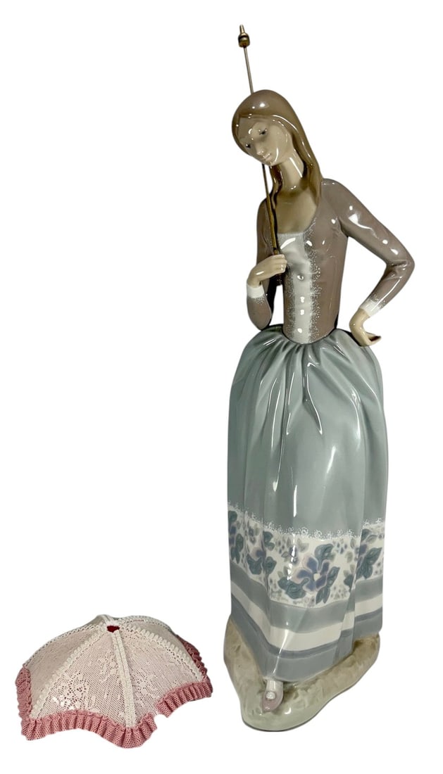 Lladro Spain Lady with Parasol Porcelain Fig 4805: Lladro Spain, porcelain figurine Lady with Parasol model 4805, depicting a woman holding a parasol, soft glazed finish with muted gray blue tones and floral detail, includes fabric parasol, marked Han