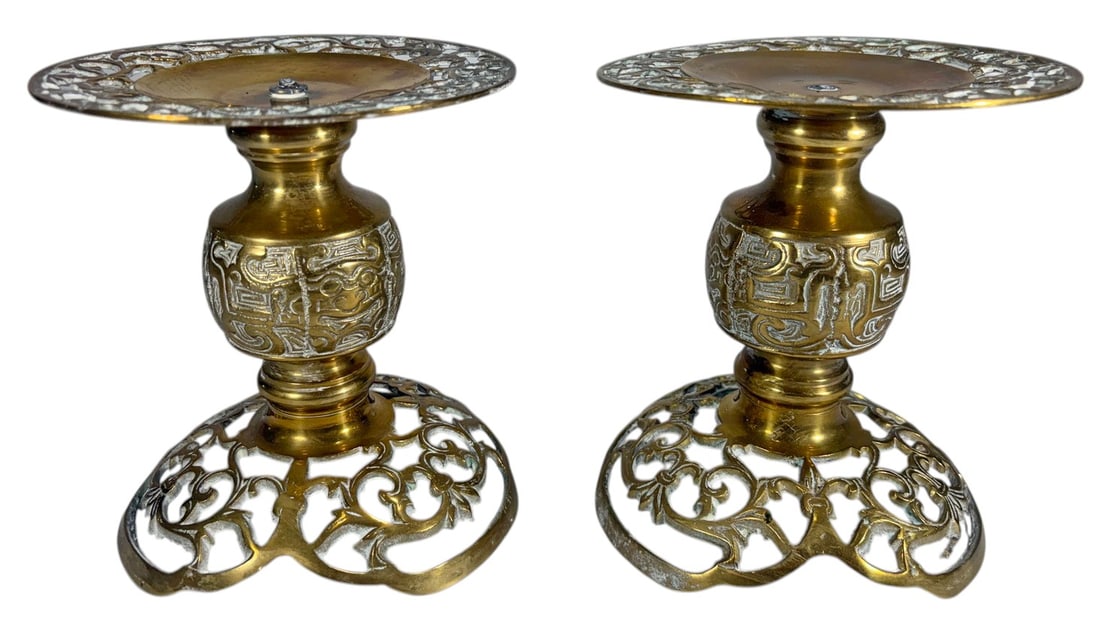 Vintage Asian Ornate Brass Candle Holders 2pc LOT: Asian style, pair of cast brass candle holders with openwork bases, pierced drip pans, and decorative relief motifs, mid 20th century design. Each piece measures approximately 6 inches tall by 5.25 in