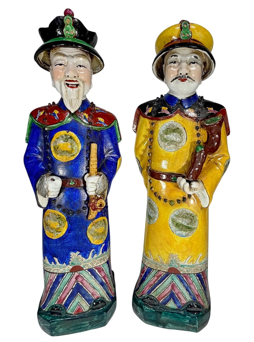 Pair Chinese Glazed Ceramic Dignitary Figures: Pair of Chinese ceramic figures depicting male court officials in traditional robes, one in blue and one in yellow, each with detailed hand painted decoration including dragon roundels, geometric bord
