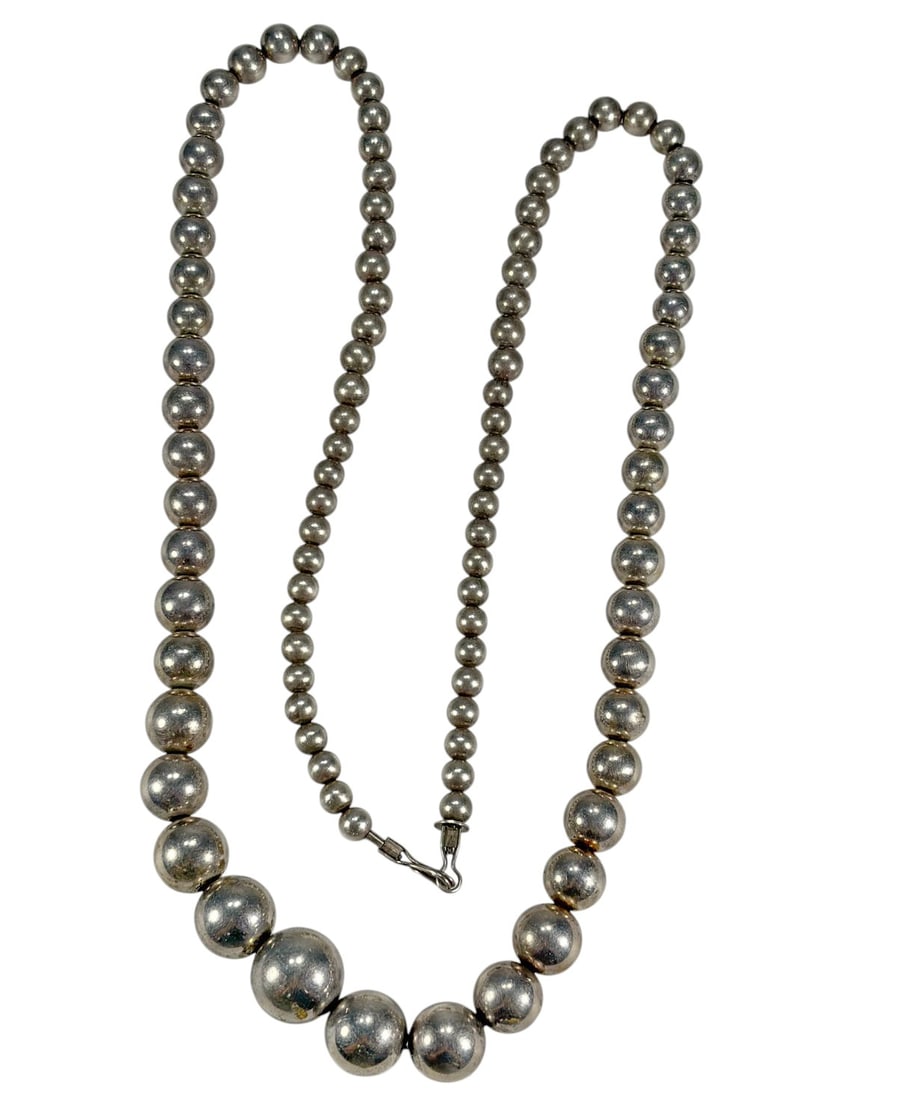 Sterling Silver 925 Graduated Bead Necklace: Graduated bead necklace composed of round sterling silver beads increasing in size toward the center. Marked 'Sterling' on the clasp. Strung in a continuous strand with hook closure. Total length meas