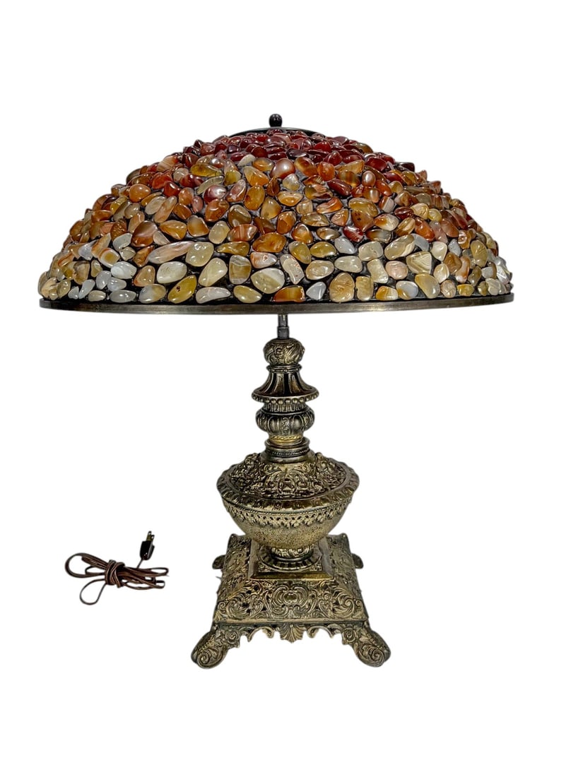 Metal Table Lamp with Semi Precious Stone Shade: Metal table lamp with ornate cast base and column, fitted with a domed mosaic shade of polished semi-precious stone fragments in amber, red, cream, and brown tones, with pierced metal cap and dual soc
