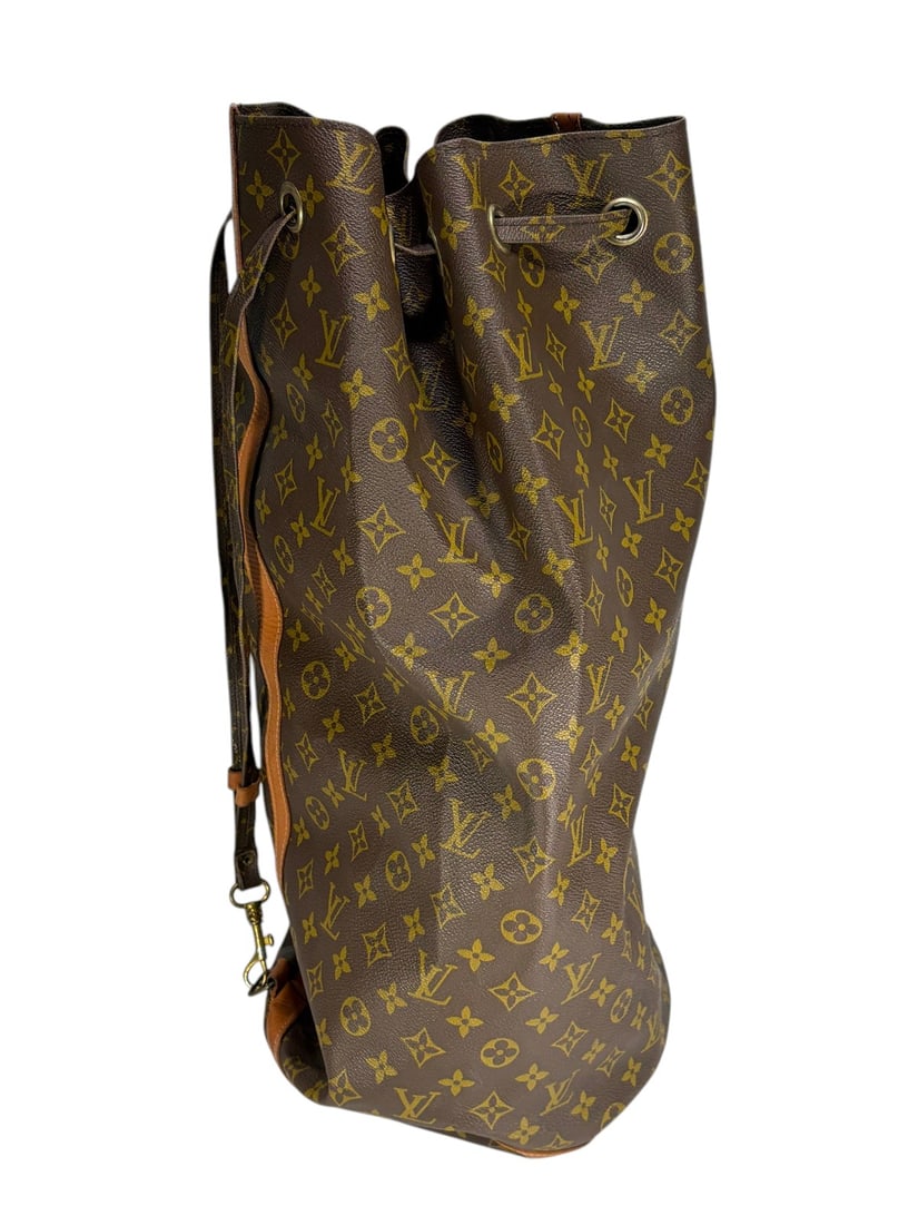 Louis Vuitton Style Monogram Drawstring Duffle Bag: Louis Vuitton style monogram drawstring duffle bag, brown coated canvas with tan LV style monogram pattern, tan leather trim and vertical strap, drawstring top with metal grommets, adjustable shoulder