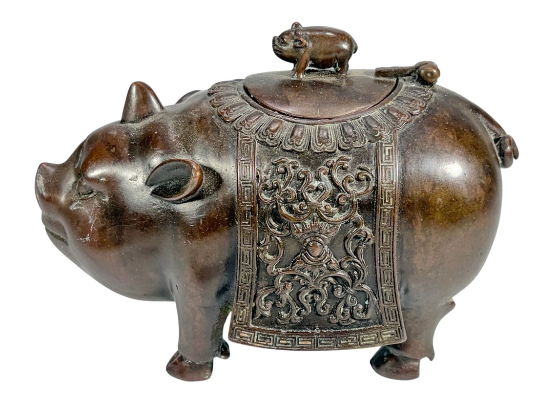 Chinese Patinated Bronze Pig Form Box with Lid: Cast bronze figural vessel in the form of a pig, the body serving as a lidded container, with hinged cover topped by a small pig finial, exterior decorated with relief scrollwork panel and geometric b