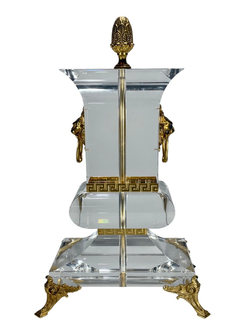 Lucite & Gilt Metal Table Lamp Base w/ Gilt Mounts: Lucite table lamp base with gilt metal mounts, featuring a stepped clear acrylic body with central column, decorative Greek key banding, and ornate gilt metal elements including paw feet and lion head