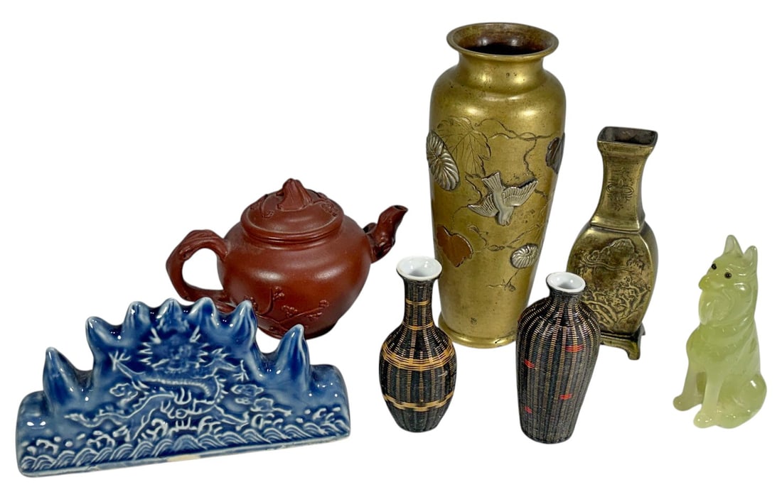 Mixed Materials Asian Teapot, Vases & Figures 7pcs: Mixed group in bronze, porcelain, and jadeite, including brass vases, red clay teapot, small porcelain vases, blue dragon brush rest, and carved jadeite dog figure. The tallest measures approximately 