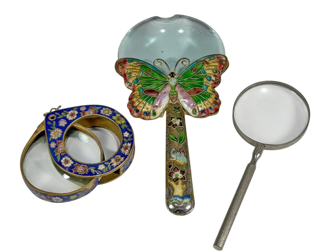 Assorted Enamel & Metal Magnifiers 3pc LOT: Group of three magnifiers. Includes one silver-tone steel example, one bronze magnifier with cloisonne enamel decoration, and one metal magnifier with butterfly and floral enamel design. Glass lenses.