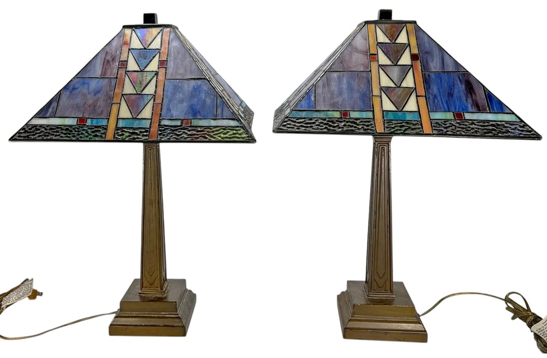 Pair Art Deco Tiffany Style Glass Table Lamps: Two-piece lot of table lamps featuring geometric art glass shades in a Tiffany style, with multicolor panels in blue, amber, cream, and red tones. The shades are constructed in a leaded style with ang