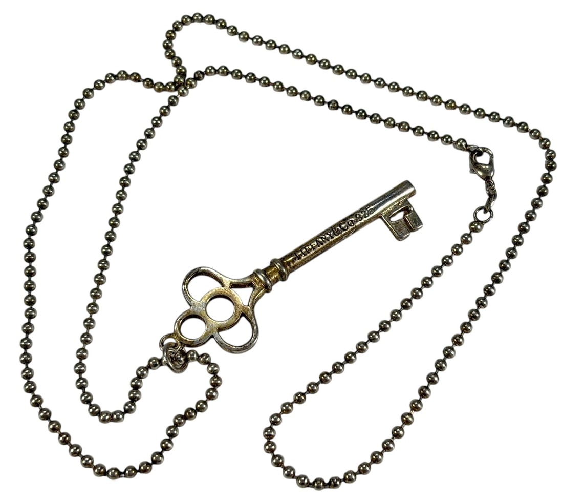 Tiffany & Co Sterling Silver Key Pendant Necklace: Sterling silver necklace featuring an original Tiffany & Co. key-form pendant suspended from a sterling silver ball chain necklace. The key pendant is marked 'Tiffany & Co. 925.' The accompanying chai