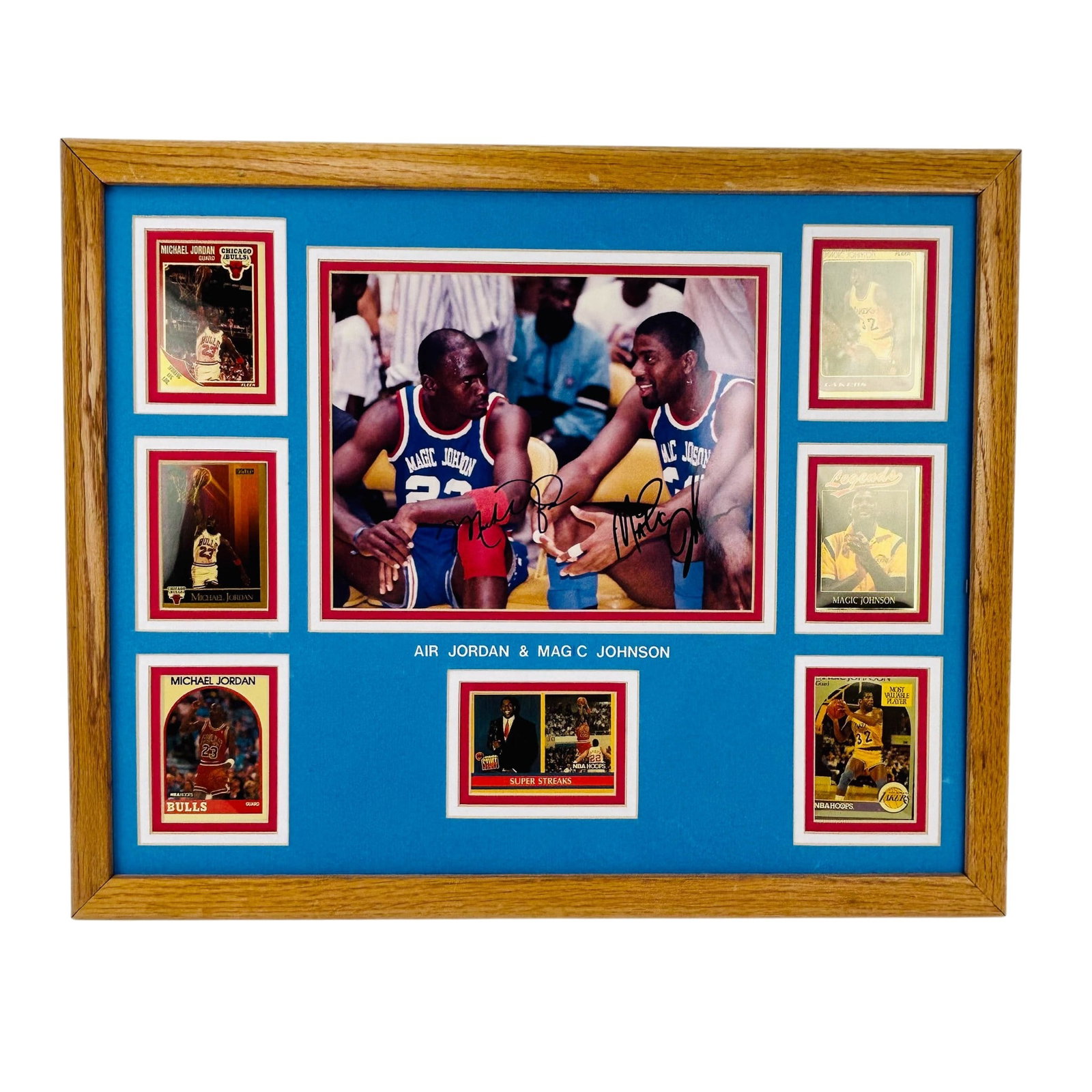 Jordan & Magic Johnson Display Card Photo SIGNED: Michael Jordan and Magic Johnson framed display featuring a central color photograph of the two players seated courtside, signed in marker. Surrounding the image are multiple basketball trading cards