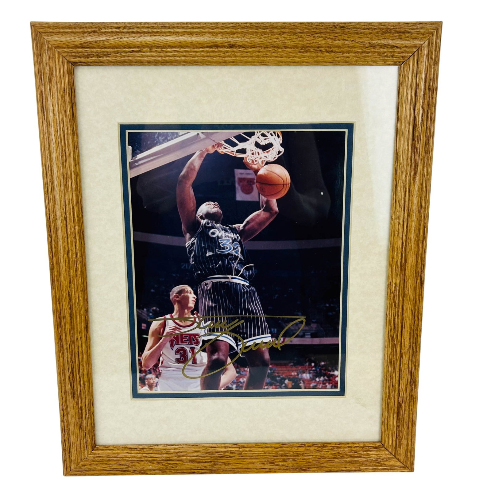 Shaquille O'Neal Orlando Magic Color Photo SIGNED: Shaquille ONeal framed color photograph depicting the player in an Orlando Magic uniform performing a dunk during game play. Signed in gold marker across the lower portion. Presented under glass with