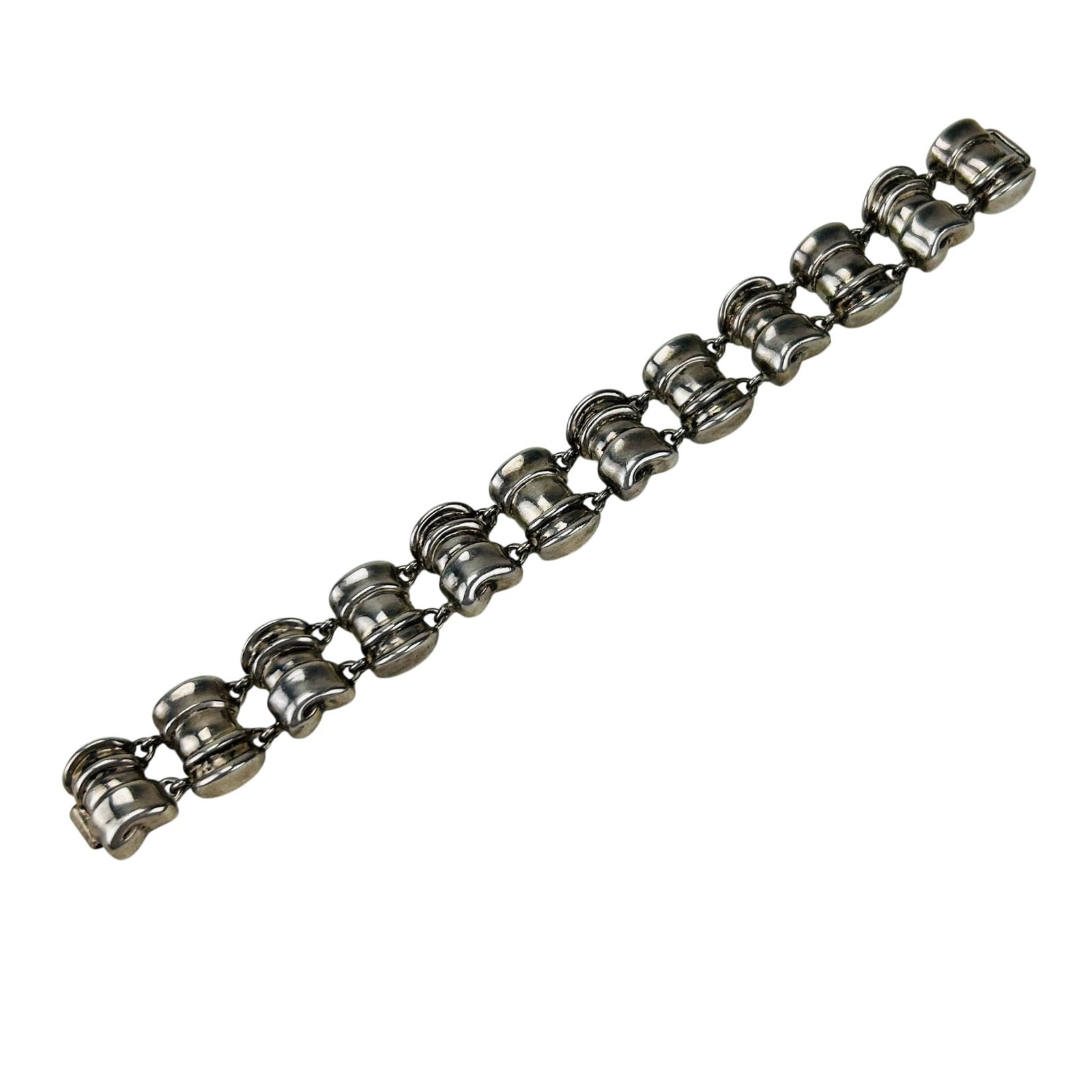 Dunigan Sterling Silver Geometric Link Bracelet: Dunigan sterling silver 925 bracelet featuring articulated dimensional geometric links with simple clasp. Measures approximately 6.5" x approximately .50". Stamped Dunigan sterling copr. 1988. Total