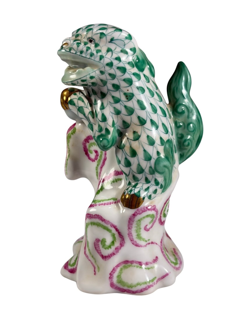 Herend Hungary Green Fishnet Foo Dog Figure: Herend Hungary hand-painted porcelain foo dog figure, decorated in the classic green fishnet pattern with gilt accents, modeled seated atop a stylized pedestal with pink and green scroll decoration. M