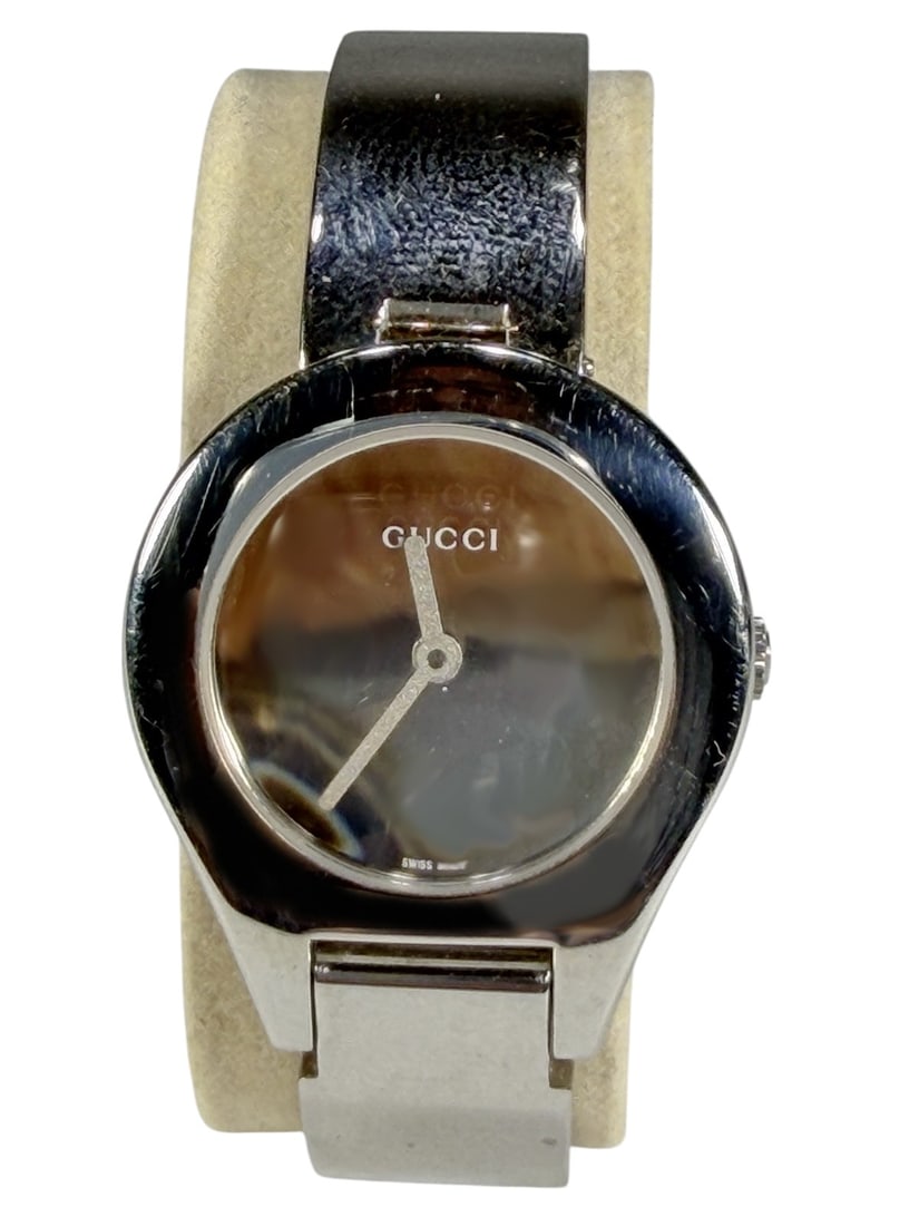 Gucci 3600L Ladies Silver Tone Quartz Wristwatch: Ladies Gucci 3600L Swiss made quartz wristwatch with silver tone bangle bracelet and black dial. Features minimalist round case design, Gucci signed clasp, and polished stainless steel finish. Include