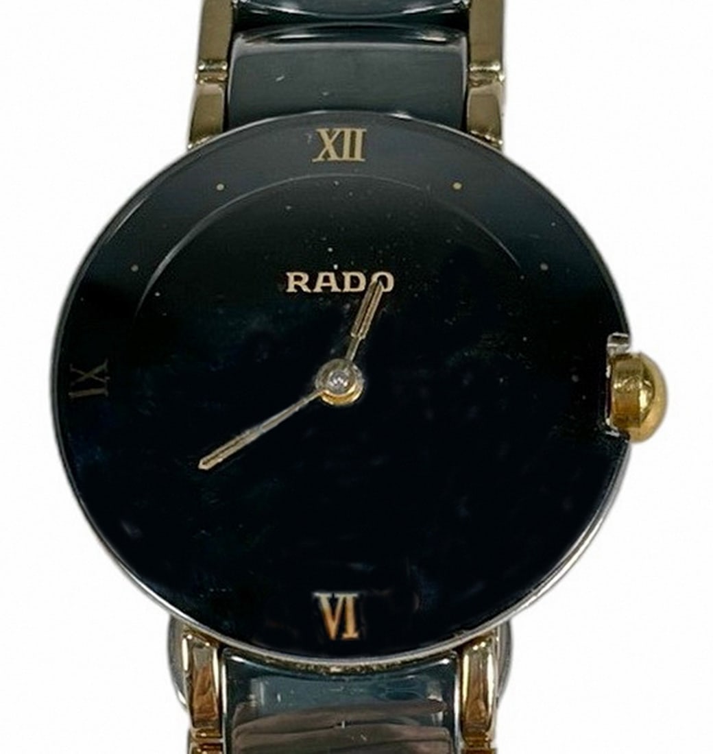 Ladies Rado DiaStar Black Ceramic Wristwatch: Ladies Rado DiaStar Swiss made quartz wristwatch with black dial, gold tone accents, and ceramic bracelet. Features vintage 1990s styling with streamlined oval case measuring approximately 23 mm in di