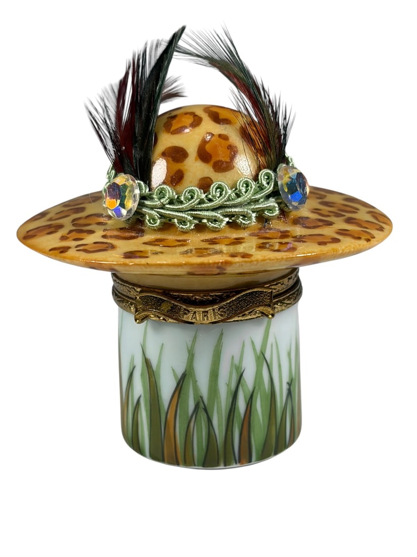 Peint Main Limoges France Cheetah Hat Trinket Box: Peint Main Limoges France hand-painted porcelain trinket box modeled as a fashionable ladys hat with cheetah pattern decoration, feather accent, jeweled embellishment, and gilt metal hinged mount. Mar