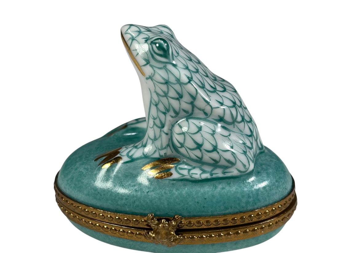 Peint Main Limoges Porcelain Frog Trinket Box: Hand painted Limoges porcelain trinket box in the form of a frog, marked Peint Main Limoges France on the underside. Features a hinged brass tone mount with clasp closure and green interior accent dec