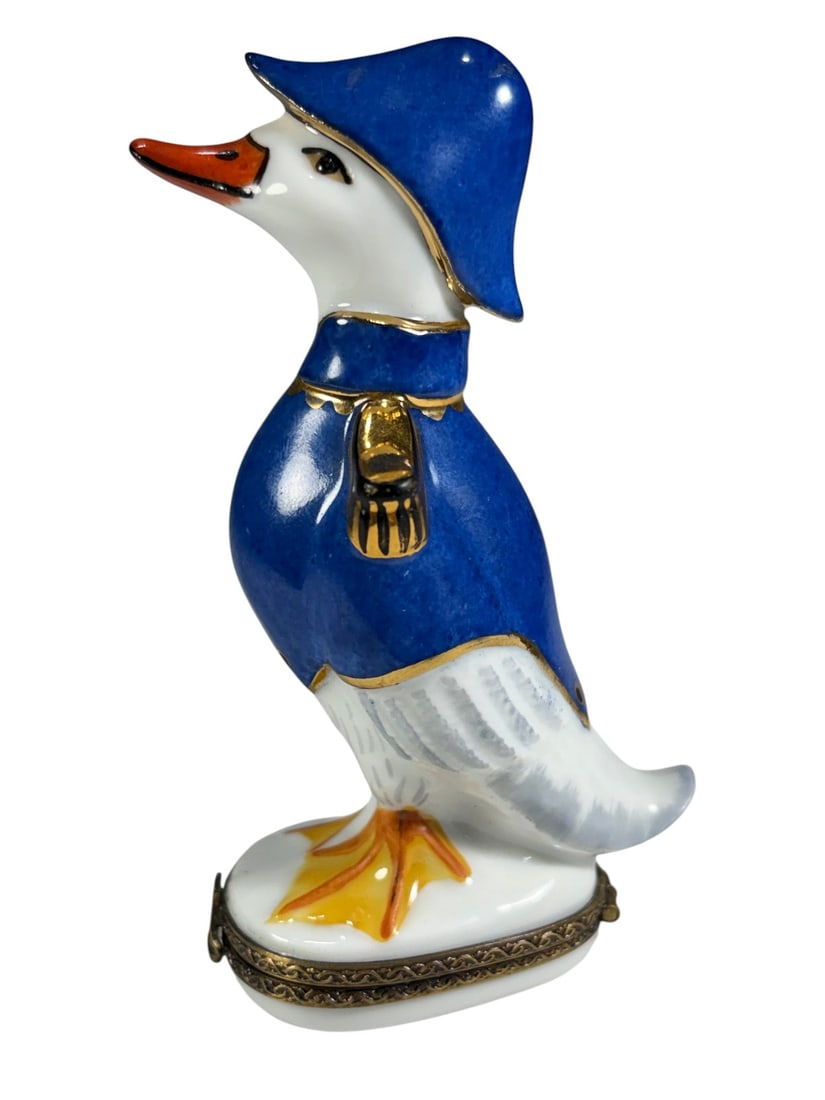Limoges France Peint Main Hinged Goose Trinket Box: French Limoges porcelain trinket box, hand-painted (Peint Main), modeled as a standing goose dressed in a blue military-style coat and hat with gilt accents. Hinged box with gilt metal mount and sailb