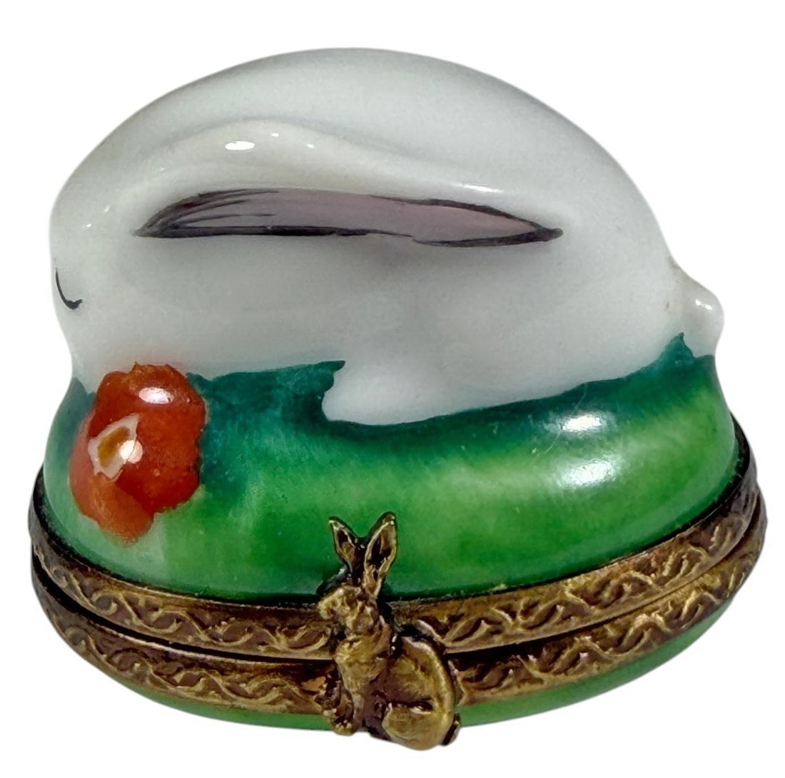Limoges France Peint Main Rabbit Trinket Box: French Limoges porcelain trinket box modeled as a sleeping white rabbit resting on a green grassy base with hand-painted details and gilt metal mount. Features a hinged lid with rabbit-form clasp. Mar
